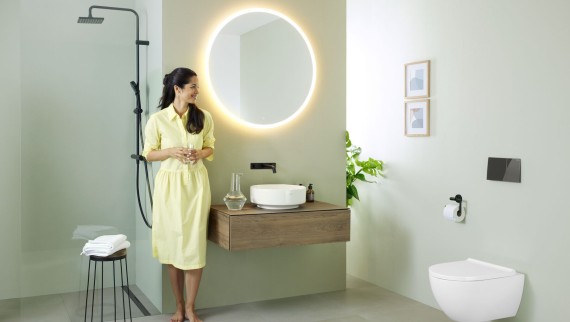 Frau in Badezimmer mit Geberit Option Spiegel und Geberit VariForm Waschbecken